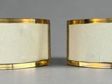 pair of white and gold candle holders with gold rims