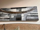 une horloge accrochée au mur au-dessus d'un lit, avec un tableau accroché au mur