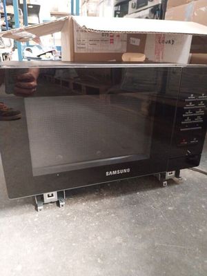 a microwave that is sitting on the floor in a warehouse