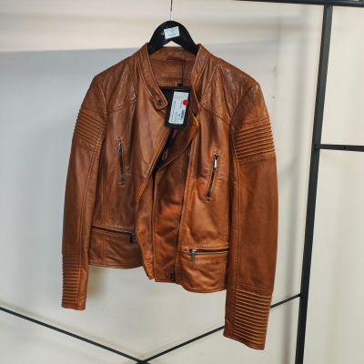 une veste en cuir marron suspendue à un porte-manteau dans une pièce
