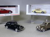 Deux voitures miniatures sont exposées dans une vitrine posée sur une table.