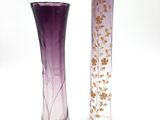 two purple vases sitting next to each other on a white surface