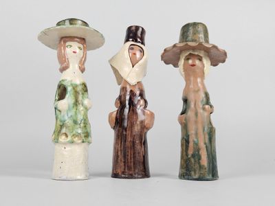 trois figurines en céramique représentant des femmes portant un chapeau et un foulard sur la tête