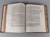 an open book on a table with a pen in it