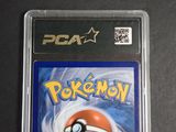 the pokemon card is in a plastic case on a black surface