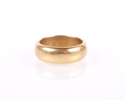 gros plan d'une bague en or sur une surface blanche