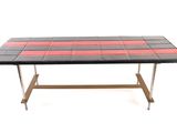 the table is made of black and red tiles with a metal base