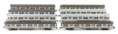 two white and brown train cars sitting next to each other on a white surface