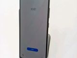 a close up of the back of a phone with a blue button on it