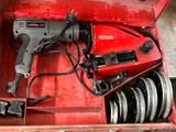une boîte à outils rouge contenant une perceuse et d'autres outils
