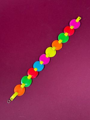 a close up of a colorful bracelet on a purple surface