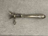 a silver knife that is laying on top of a table