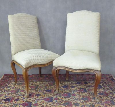 une paire de chaises de salle à manger rembourrées posées sur un tapis