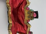 someone is holding a red purse with a gold crown on it