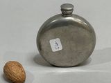 a flask and a nut on a white surface