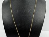 a gold necklace with pearls and a flower on a mannequin