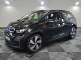 the bmw i3 is parked on a checkered floor in a garage