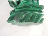 a close up of a green statue on a white surface
