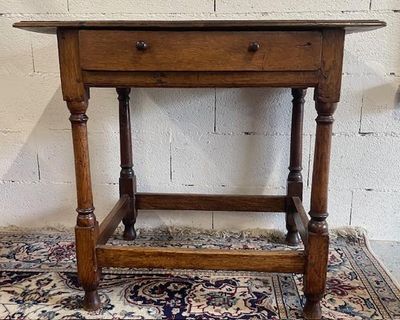 Une petite table en chêne reposant sur 4 pieds réunis entre …