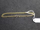 a close up of a gold chain with a tag on it