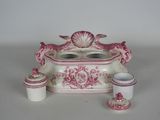 a pink and white table setting with a candle holder and cups