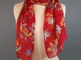 a red scarf on a mannequin torso with a red background