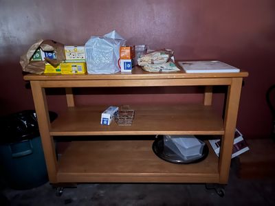 une étagère en bois sur laquelle sont posés des aliments, dans une pièce