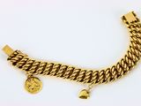 Gros plan sur un bracelet en or orné d'une pièce de monnaie