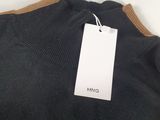 a close up of a black sweater with a tag on it