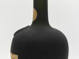 a black bottle with a brown label on it