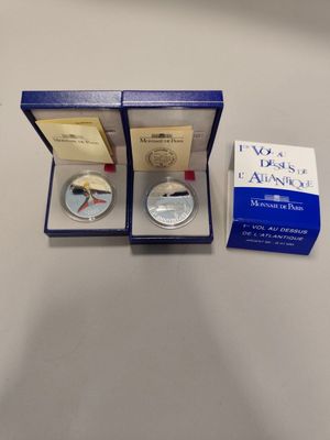 a silver coin in a blue box with a box of cards