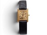 gros plan d'une montre sur une surface blanche avec un bracelet noir