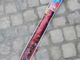 Une personne se tient sur le trottoir à côté d'un parapluie emballé dans du plastique.