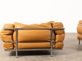 two brown leather sofas with metal legs in a room