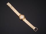 a gold watch with a white dial on a black background