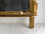 a gold frame with a mirror on top of it
