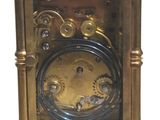 a gold clock that is sitting on a white surface