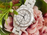 a close up of a white watch on a pink flower