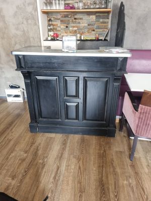 un petit bar dans un coin d'une pièce, avec un chien couché par terre