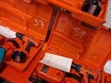 une boîte à outils orange contenant des outils, posée sur une table