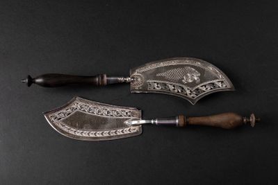 pair of silver plated knives with wooden handles on a black surface