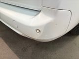 a close up of a white car that is parked on the street