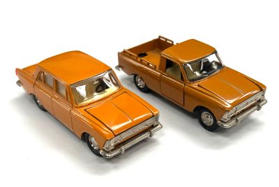 deux voitures jouets assises l'une à côté de l'autre sur une surface blanche