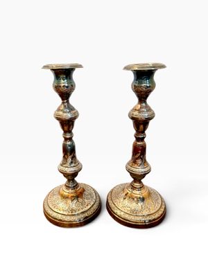 pair of antique brass candlesticks on a white background
