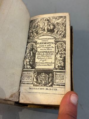 someone is holding a book in their hand and it is open