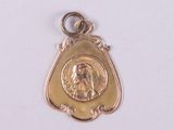 une médaille d'or avec la photo d'une femme dessus