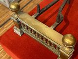 un lit en métal recouvert d'une couverture rouge, posé sur un plancher en bois