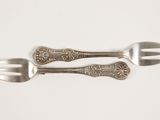 two forks and two spoons on a white surface
