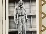 a black and white photo of a man standing in front of a building