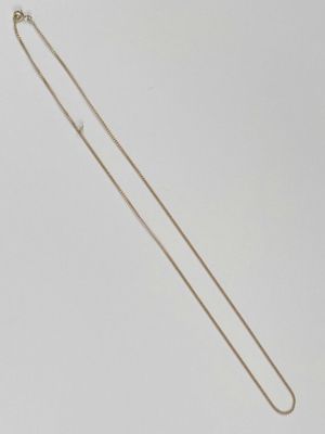 un collier en or avec une longue chaîne sur fond blanc